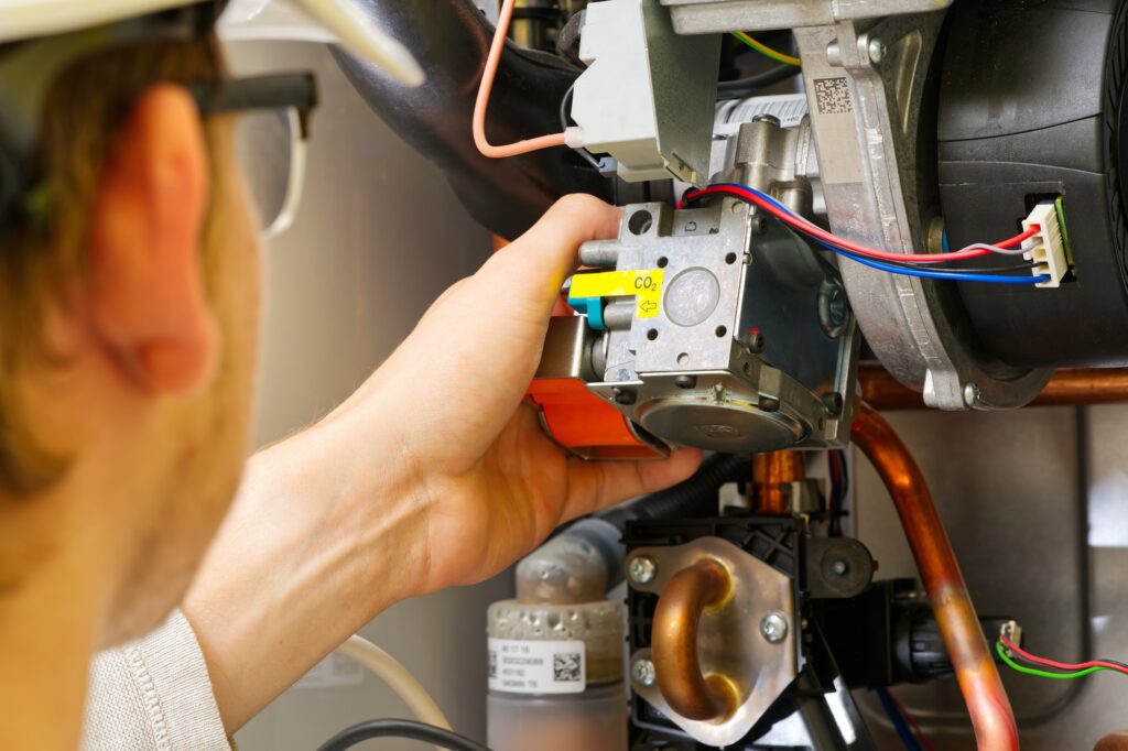 Technician servicing or Repair of a gas boiler, setting up and servicing. gas boiler for heating